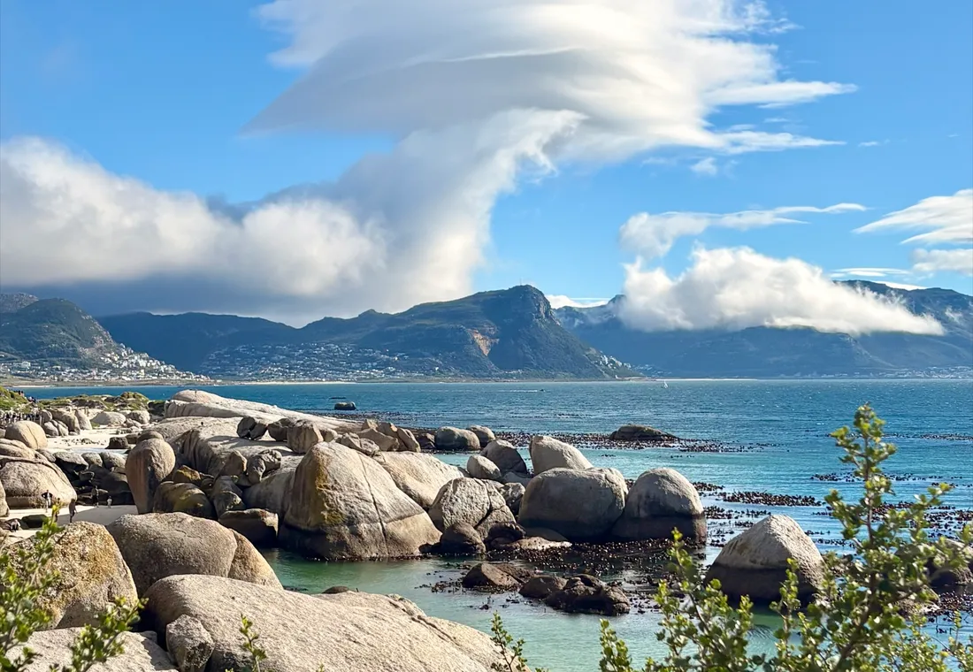 Линзовидное облако над валунами и бирюзовой водой пляжа Boulders
